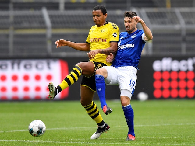 Borussia Dortmund's Manuel Akanji in action with Schalke's Daniel Caligiuri in the Bundesliga on May 16, 2020